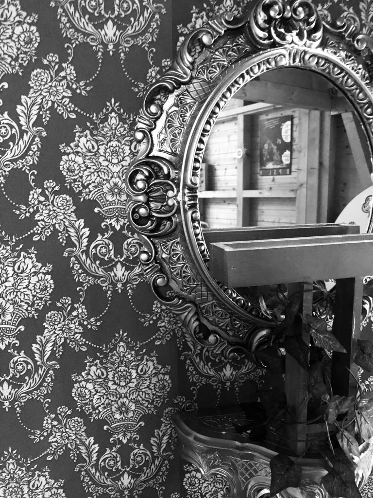 Black and white photo of a mirror on the wall
